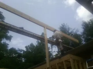 Carpenter setting a ridge beam over a new addition frame — Ice Dam Removal by Roofing Brothers in Lemont Furnace
