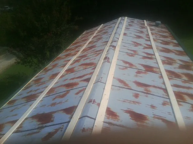 Rusted metal roof panels with new wood purlins before replacement — Storm Damage Roof Repair in Lemont Furnace by Roofing Brothers