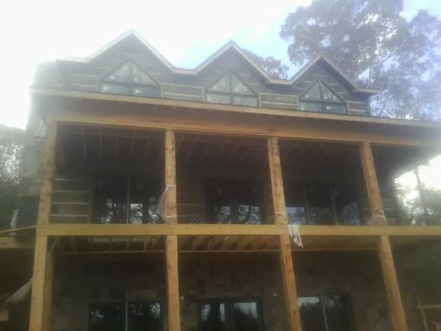 Dormers and porch framing on a large log home under construction — Roof Coating work by our crew in Lemont Furnace