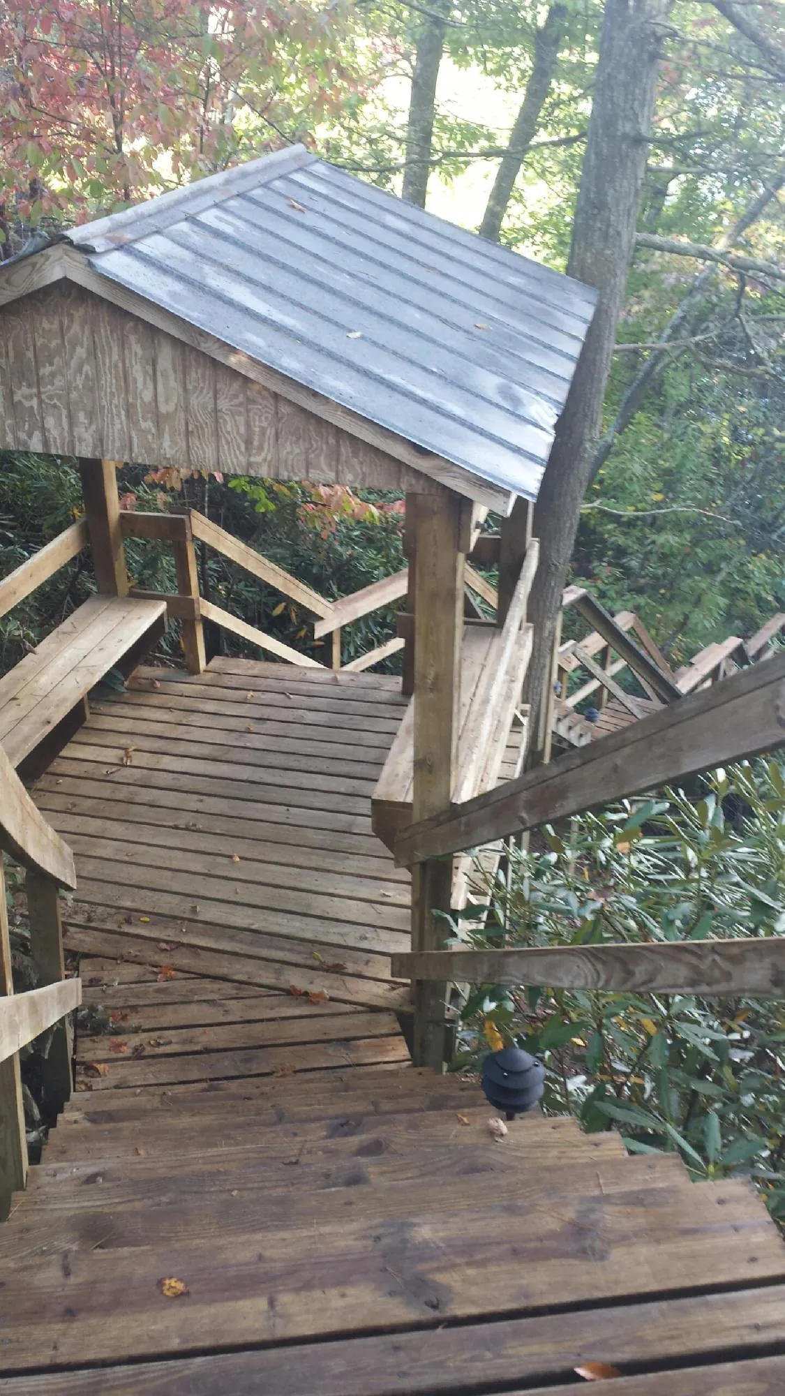 Metal roofed shelter over wooden steps on a wooded walkway — Skylight Repair & Installation work by our crew in Lemont Furnace