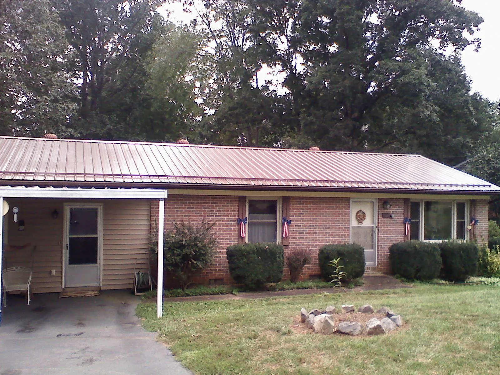 Bronze metal roof and carport on a brick ranch home — Roof Repair work by our crew in Lemont Furnace